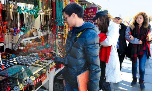 圖為近日，來自廣東的游客在選購紀念品。