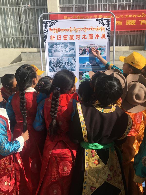 集體活動結(jié)束后，各班排隊參觀新舊西藏對比圖片展。圖為五年級的歐珠旺姆和央青措姆擔任解說員，分別為同學們講解新舊西藏圖片。.JPG