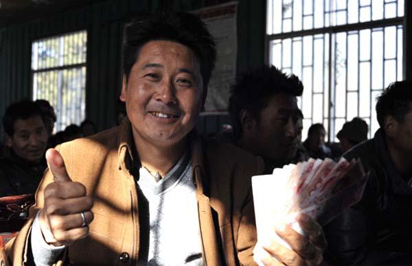 崗巴村一村民領(lǐng)到生態(tài)補(bǔ)償金后，豎起大拇指夸贊黨和國家的生態(tài)環(huán)保政策 本報(bào)記者 麥正偉 攝.jpg