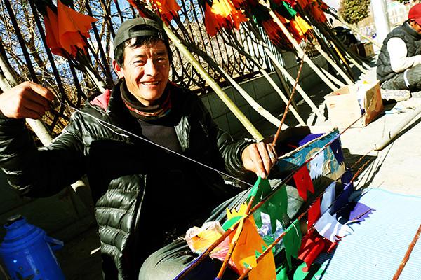 圖為：1月23日上午，來自西藏日喀則市南木林縣農(nóng)民旦增平措，在藏歷火雞新年前來山南縫制、銷售經(jīng)幡樹。他說，每天可以賣出30棵左右，每棵平均賣300元至150元不等，收入可觀。曲杰 攝.jpg