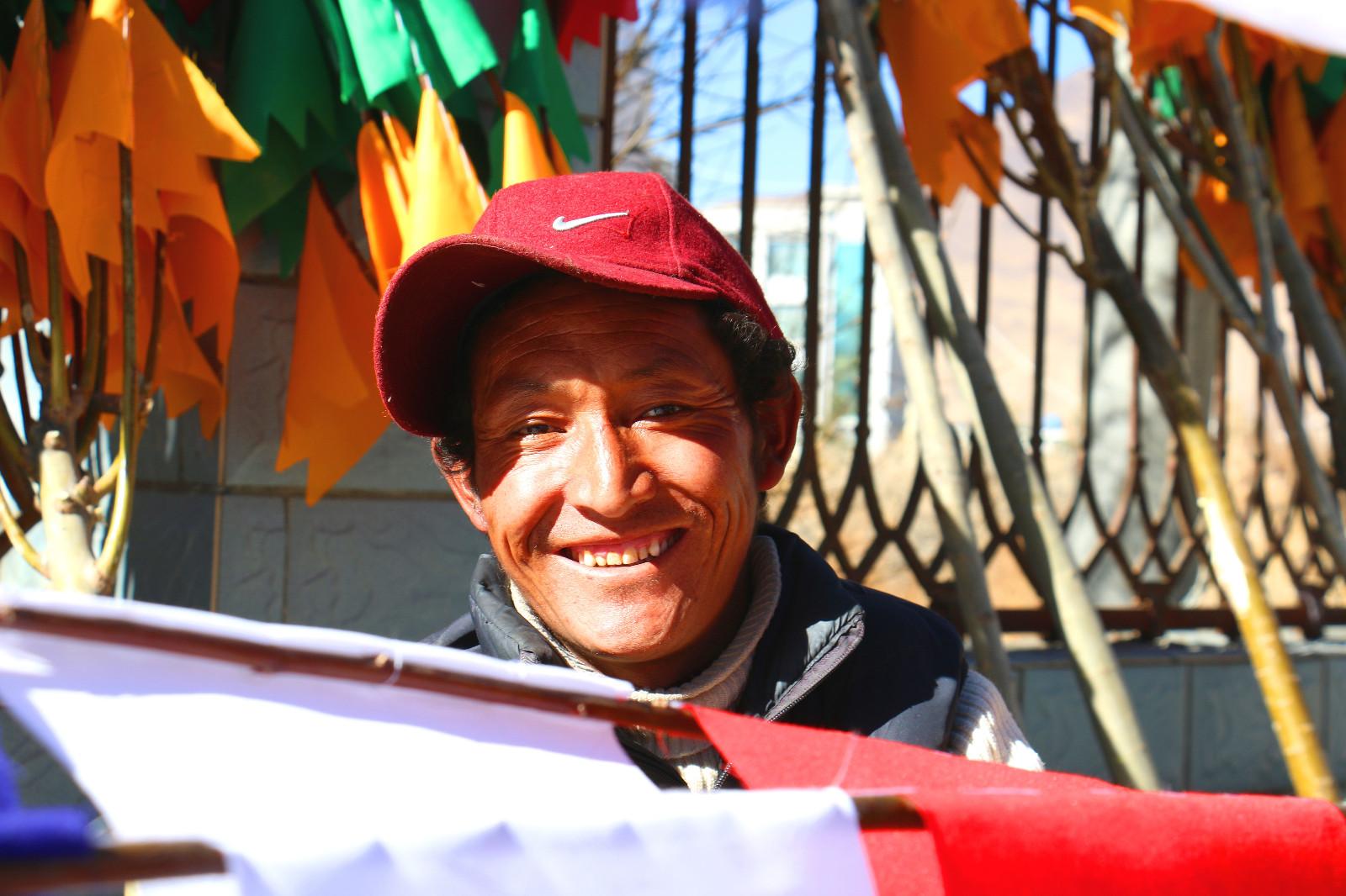 圖為：1月23日上午，來自西藏山南市乃東區(qū)亞堆鄉(xiāng)農(nóng)民索朗多吉在縫制、銷售經(jīng)幡樹。他說：“去年我和朋友合伙做經(jīng)幡樹生意賺了4萬多元，今年一個人干，感覺比去年還好，一天就有1000多元的收入。”  曲杰   攝.jpg
